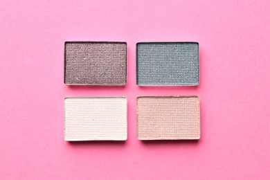 Photo of Beautiful eyeshadow refill pans on pink background, flat lay