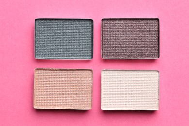 Photo of Beautiful eyeshadow refill pans on pink background, flat lay