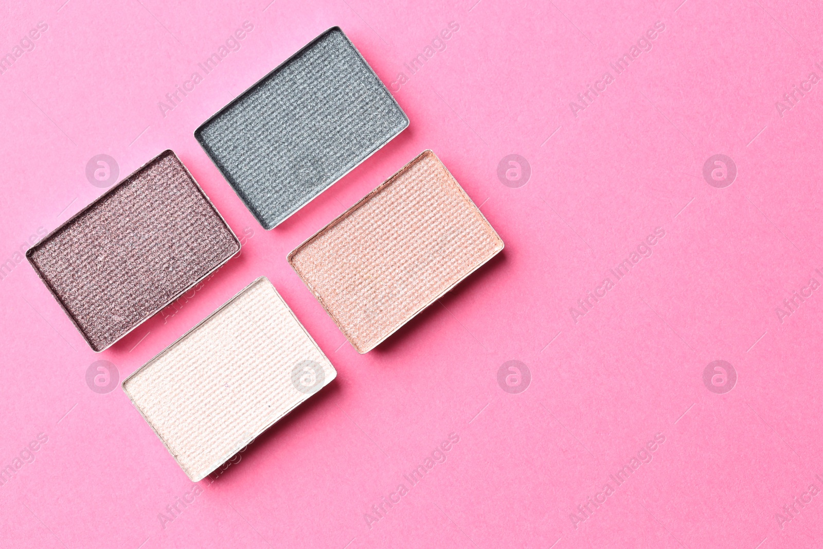 Beautiful eyeshadow refill pans on pink background, flat lay. Space for text Photo of Beautiful eyeshadow refill pans on pink background, flat lay. Space for text