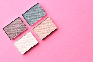 Photo of Beautiful eyeshadow refill pans on pink background, flat lay. Space for text