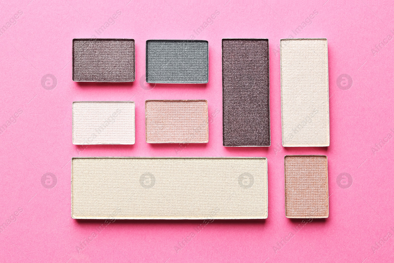 Beautiful eyeshadow refill pans on pink background, flat lay Photo of Beautiful eyeshadow refill pans on pink background, flat lay