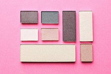 Photo of Beautiful eyeshadow refill pans on pink background, flat lay