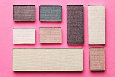 Photo of Beautiful eyeshadow refill pans on pink background, flat lay