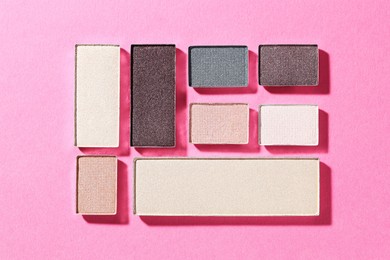 Photo of Beautiful eyeshadow refill pans on pink background, flat lay