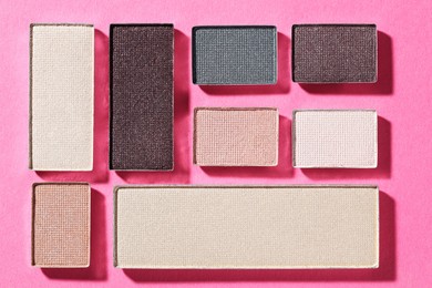 Photo of Beautiful eyeshadow refill pans on pink background, flat lay