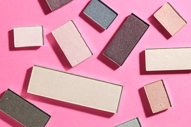 Photo of Beautiful eyeshadow refill pans on pink background, flat lay