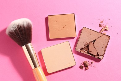 Photo of Refill pans of cosmetic products and brush on pink background, flat lay