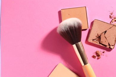 Photo of Refill pans of cosmetic products and brush on pink background, flat lay. Space for text