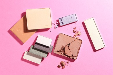 Photo of Beautiful eyeshadow refill pans on pink background, flat lay