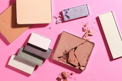 Photo of Beautiful eyeshadow refill pans on pink background, flat lay