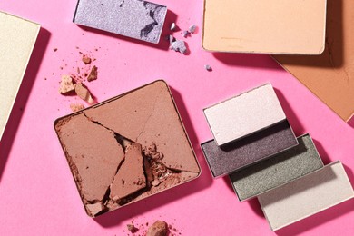 Photo of Beautiful eyeshadow refill pans on pink background, flat lay