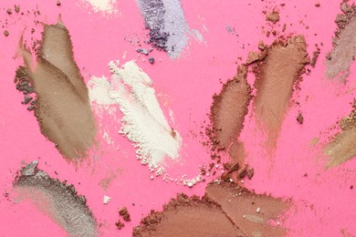 Photo of Different eyeshadows smudges on pink background, flat lay