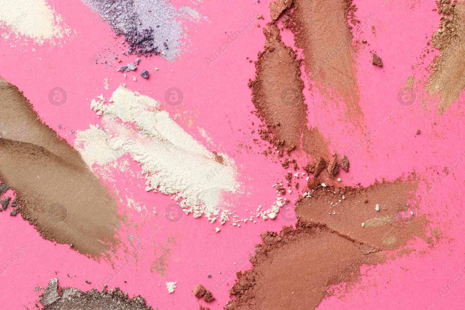 Different eyeshadows smudges on pink background, flat lay Photo of Different eyeshadows smudges on pink background, flat lay