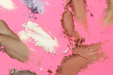 Photo of Different eyeshadows smudges on pink background, flat lay