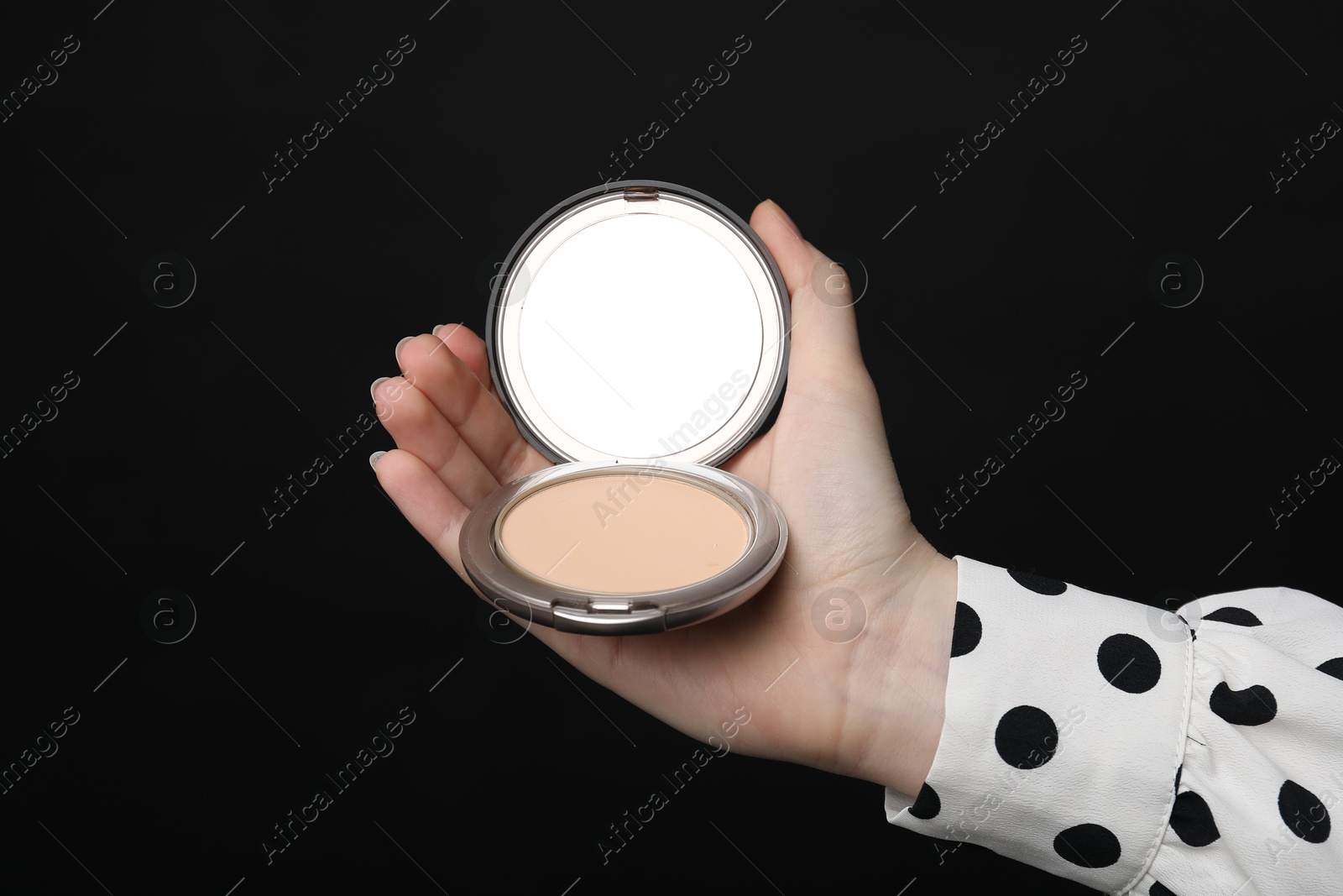 Woman holding open face powder with mirror on black background, closeup Photo of Woman holding open face powder with mirror on black background, closeup