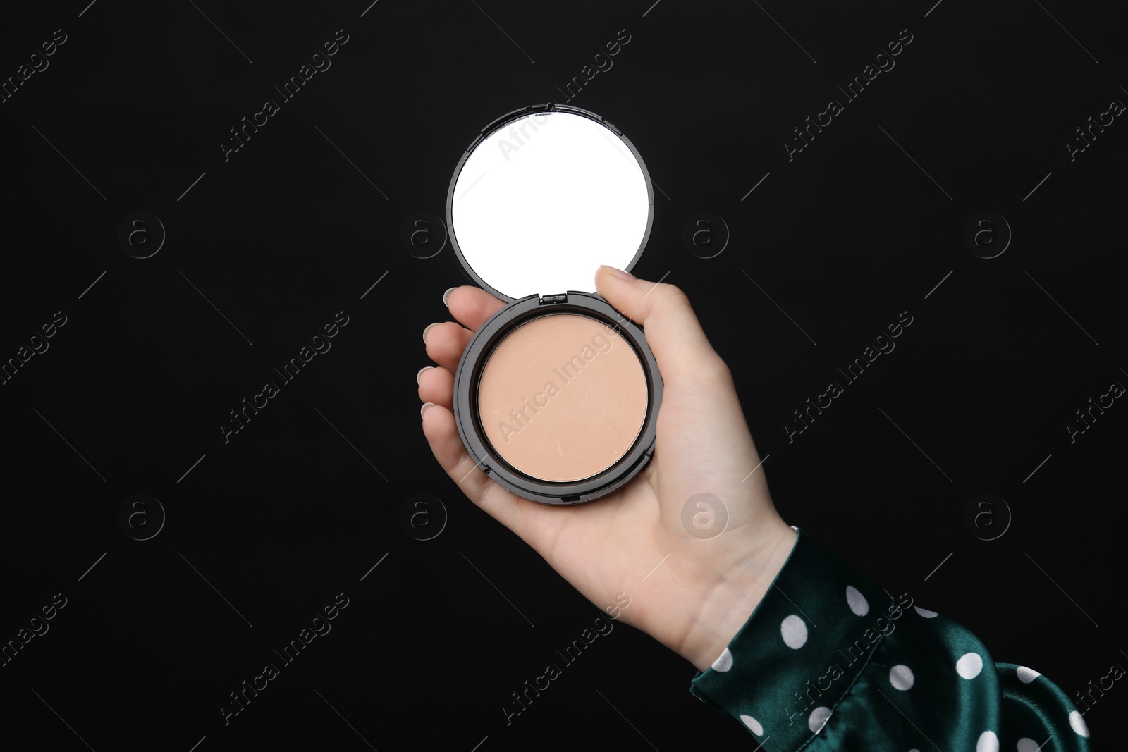 Woman holding open face powder with mirror on black background, closeup Photo of Woman holding open face powder with mirror on black background, closeup