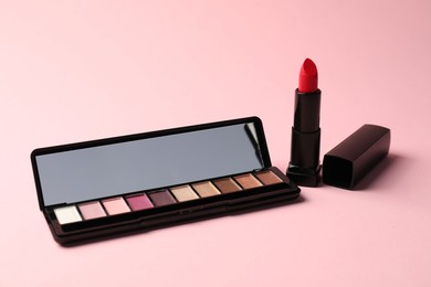 Photo of Eyeshadow palette with mirror and lipstick on pink background