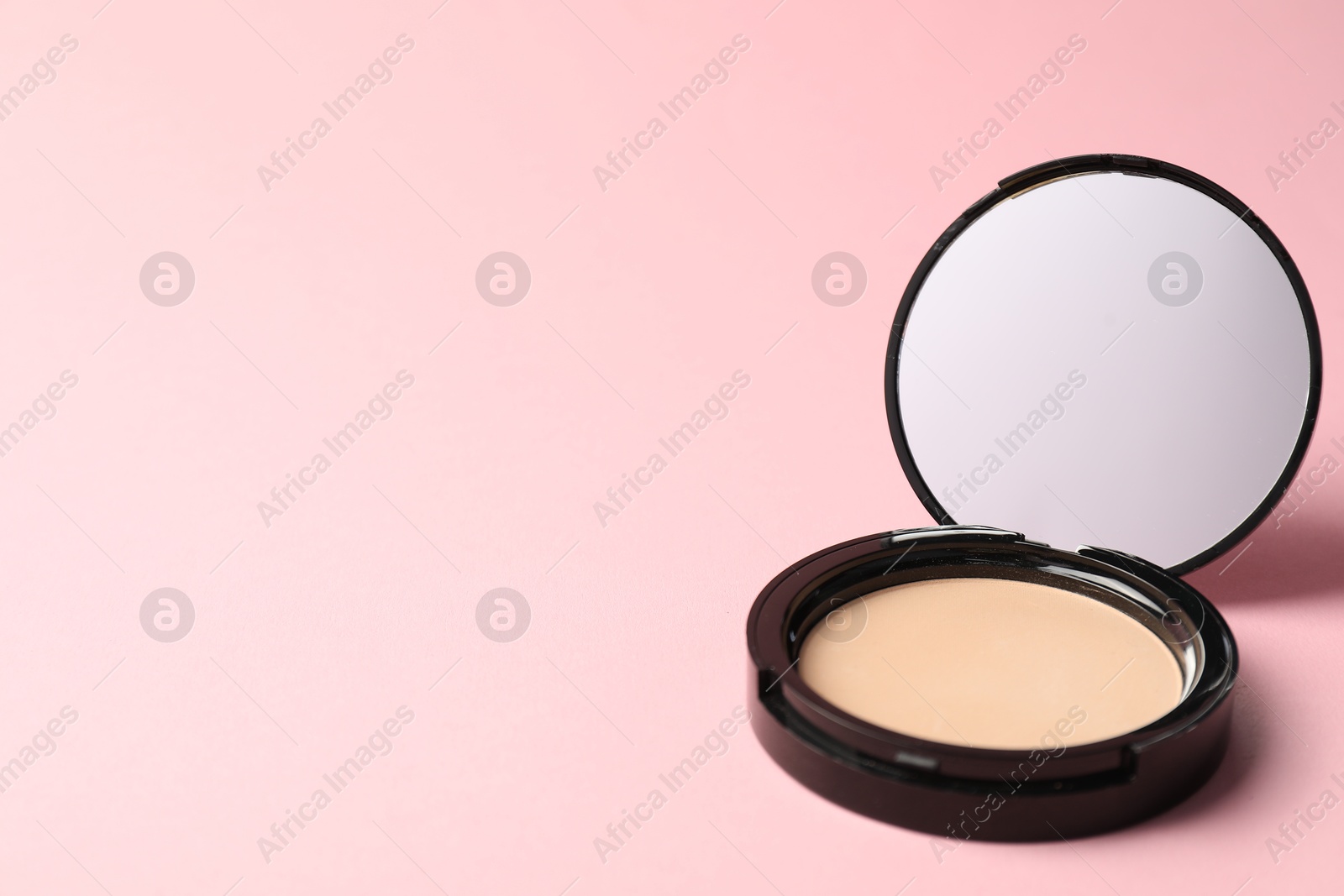 Open face powder with mirror on pink background, closeup. Space for text Photo of Open face powder with mirror on pink background, closeup. Space for text