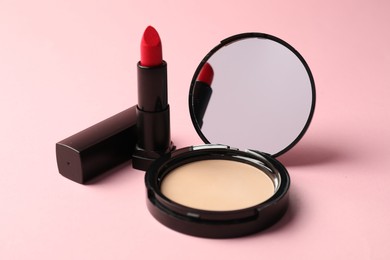 Photo of Open face powder with mirror and lipstick on pink background, closeup