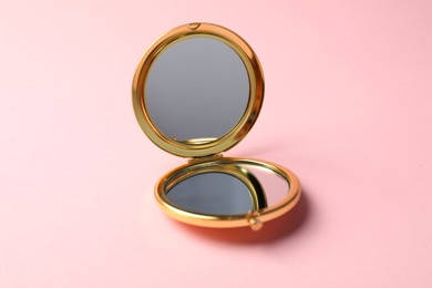 Photo of Open pocket mirror on pink background, closeup
