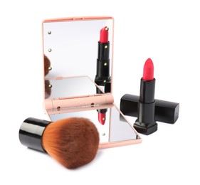 Photo of Open pocket mirror, brush and lipstick isolated on white