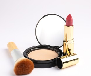 Photo of Open face powder with mirror, brush and lipstick on white background