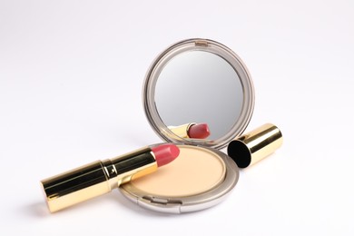 Photo of Open face powder with mirror and lipstick on white background