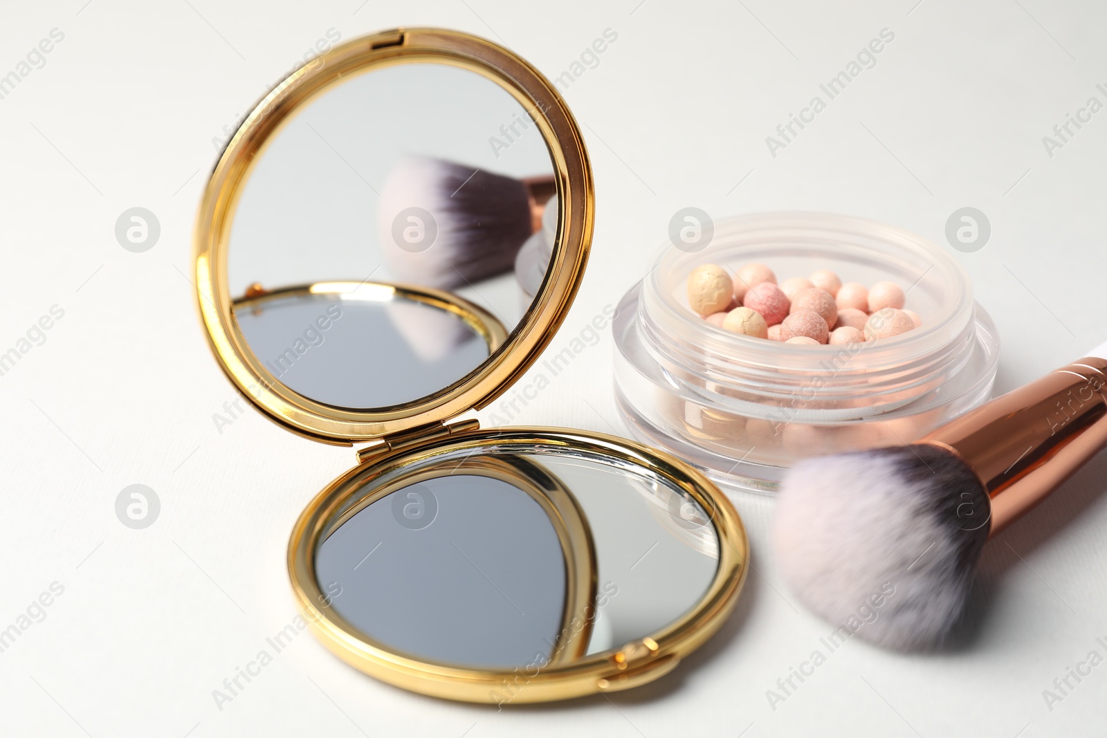 Open pocket mirror, brush and blush on light grey background, closeup Photo of Open pocket mirror, brush and blush on light grey background, closeup