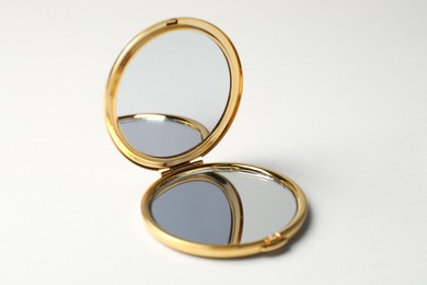 Photo of Open pocket mirror on light grey background, closeup