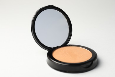 Photo of Open face powder with mirror on light grey background, closeup