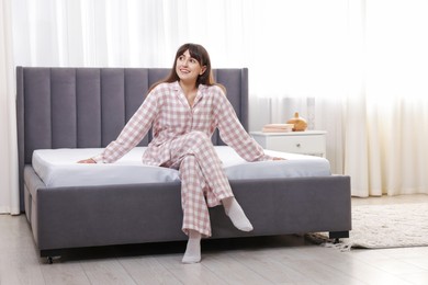 Photo of Beautiful woman sitting on soft mattress at home