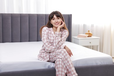 Photo of Beautiful woman sitting on soft mattress at home