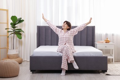 Photo of Beautiful woman sitting on soft mattress at home