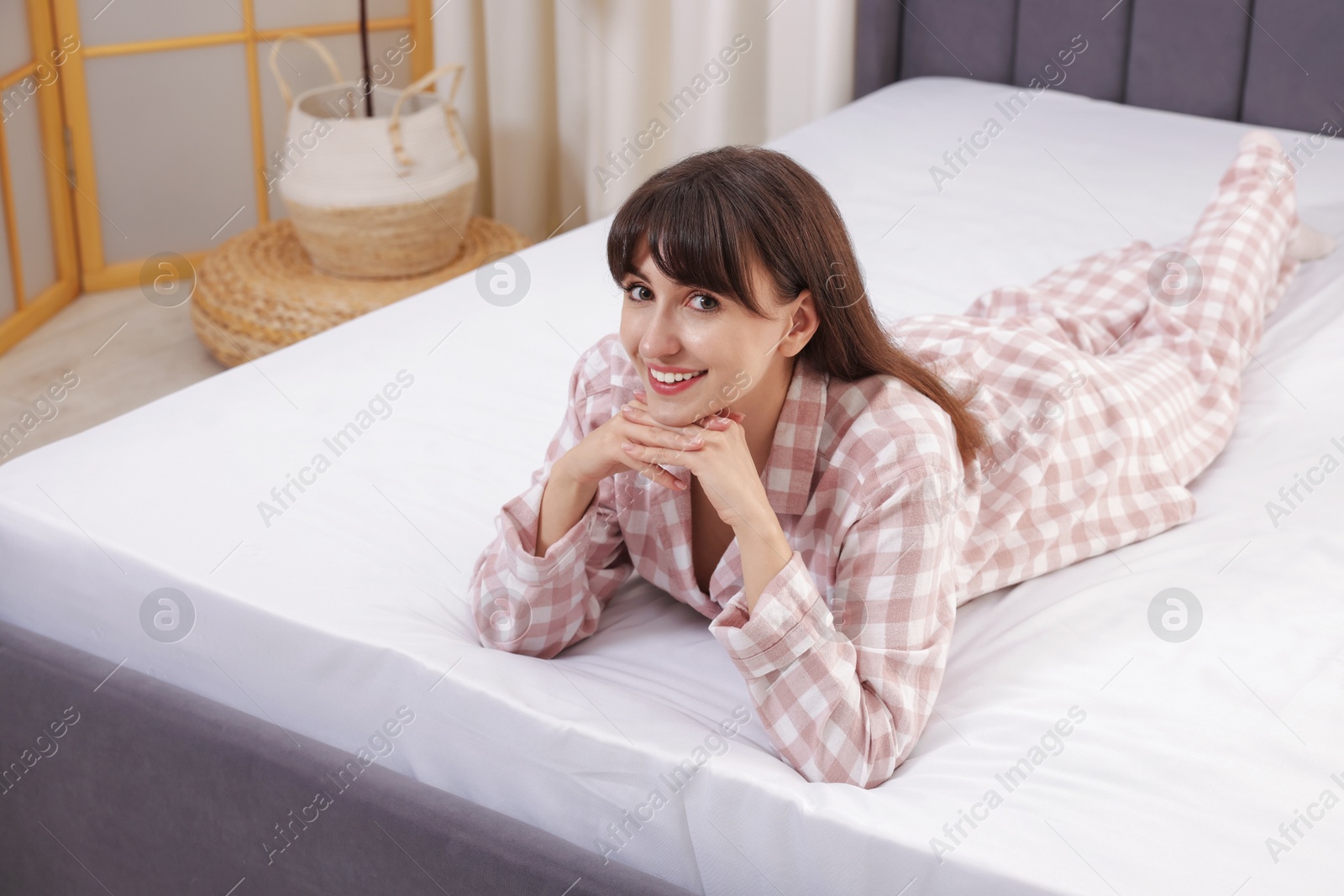 Photo of Beautiful woman lying on soft mattress at home
