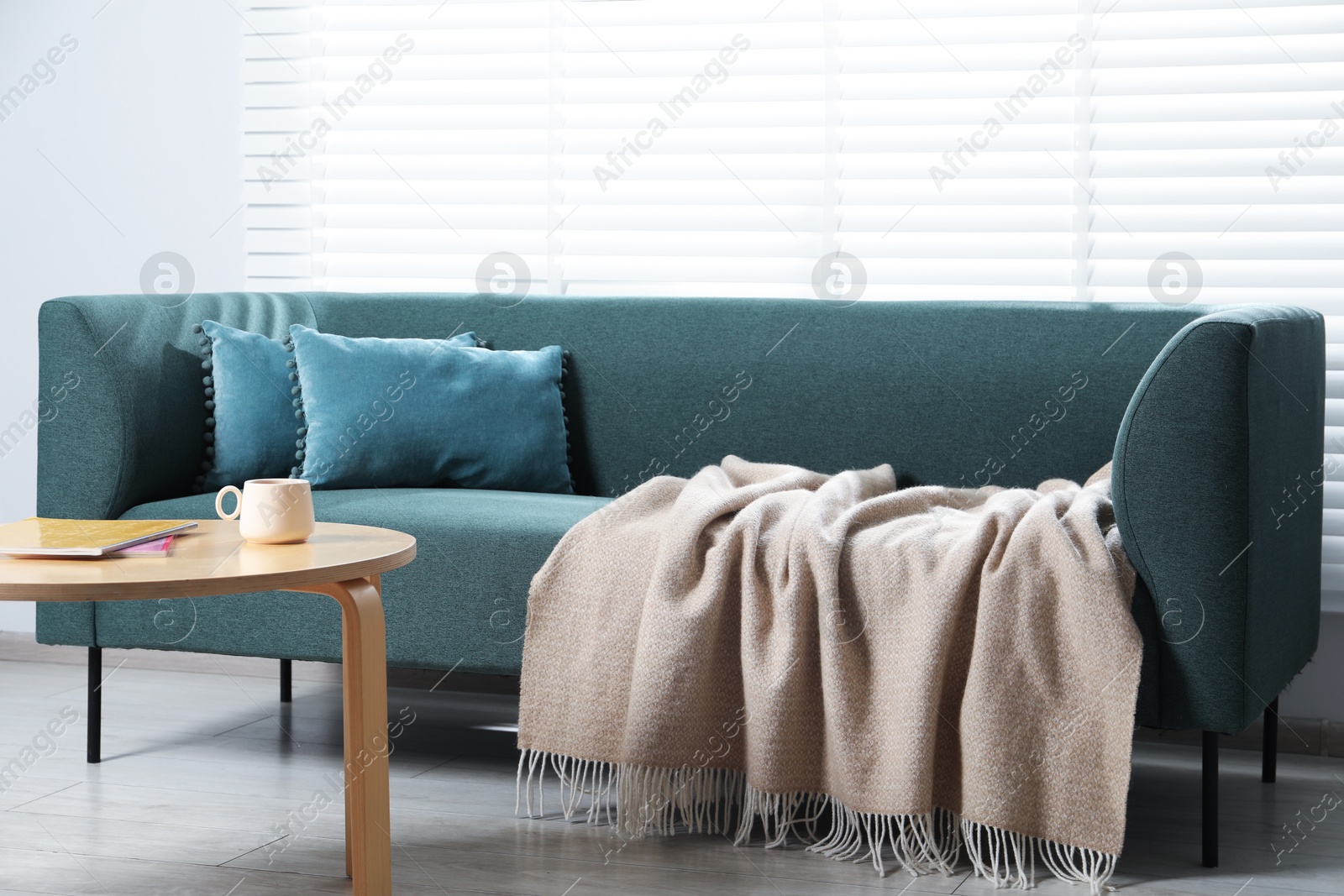 Woolen plaid on sofa and coffee table at home Photo of Woolen plaid on sofa and coffee table at home