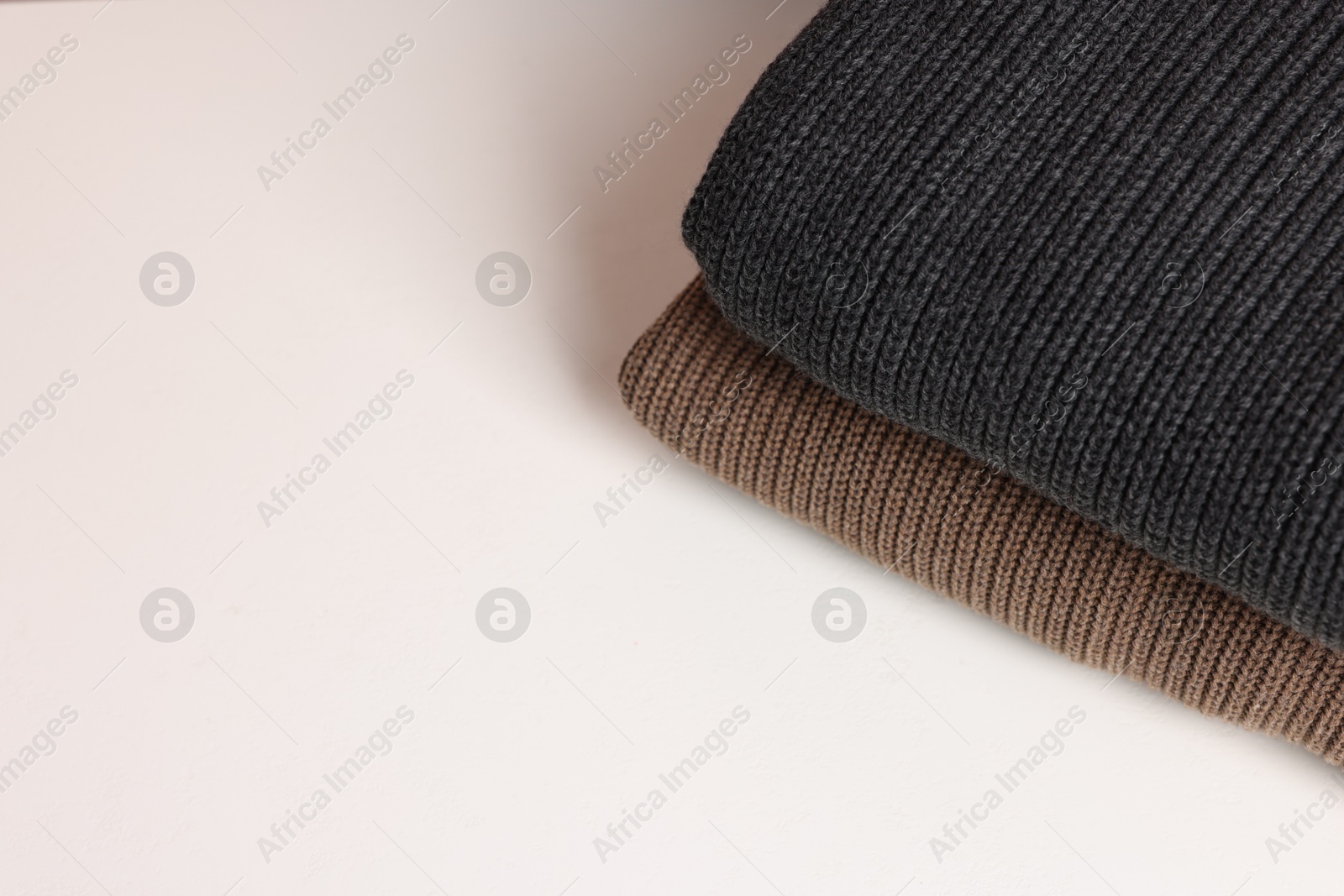 Stack of woolen sweaters on white background, top view. Space for text Photo of Stack of woolen sweaters on white background, top view. Space for text