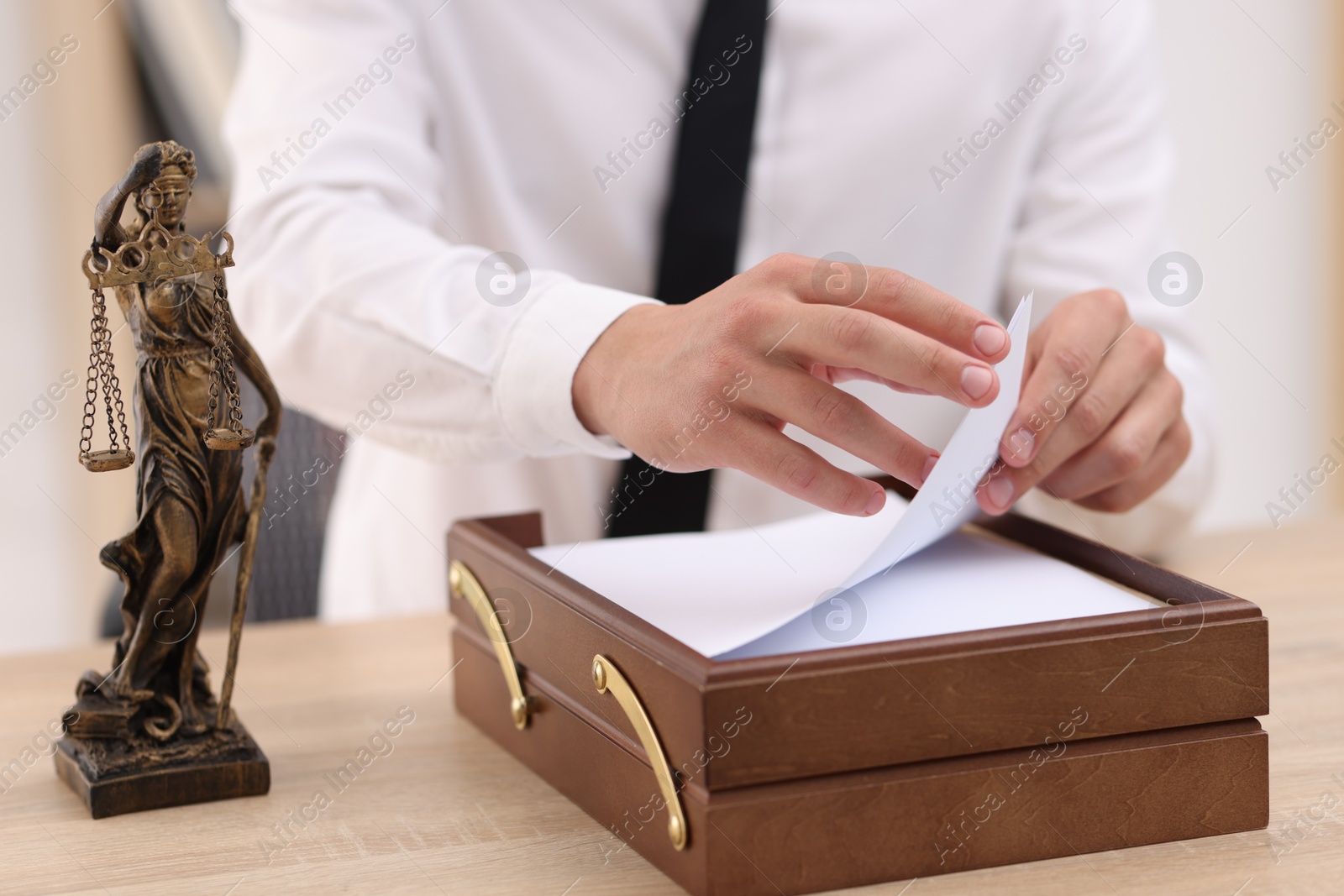 Judge working and Lady Justice figure on desk indoors, selective focus Photo of Judge working and Lady Justice figure on desk indoors, selective focus