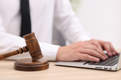Photo of Judge working with laptop and gavel on desk indoors, selective focus