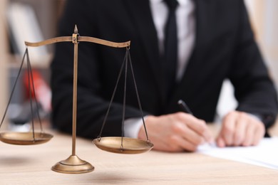 Photo of Judge working and scales on desk indoors, selective focus