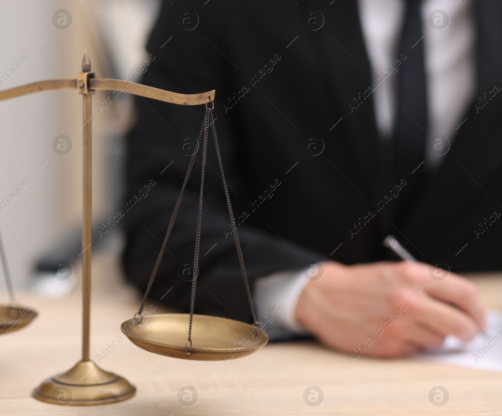 Photo of Judge working and scales on desk indoors, selective focus
