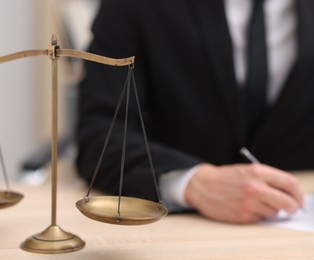 Photo of Judge working and scales on desk indoors, selective focus