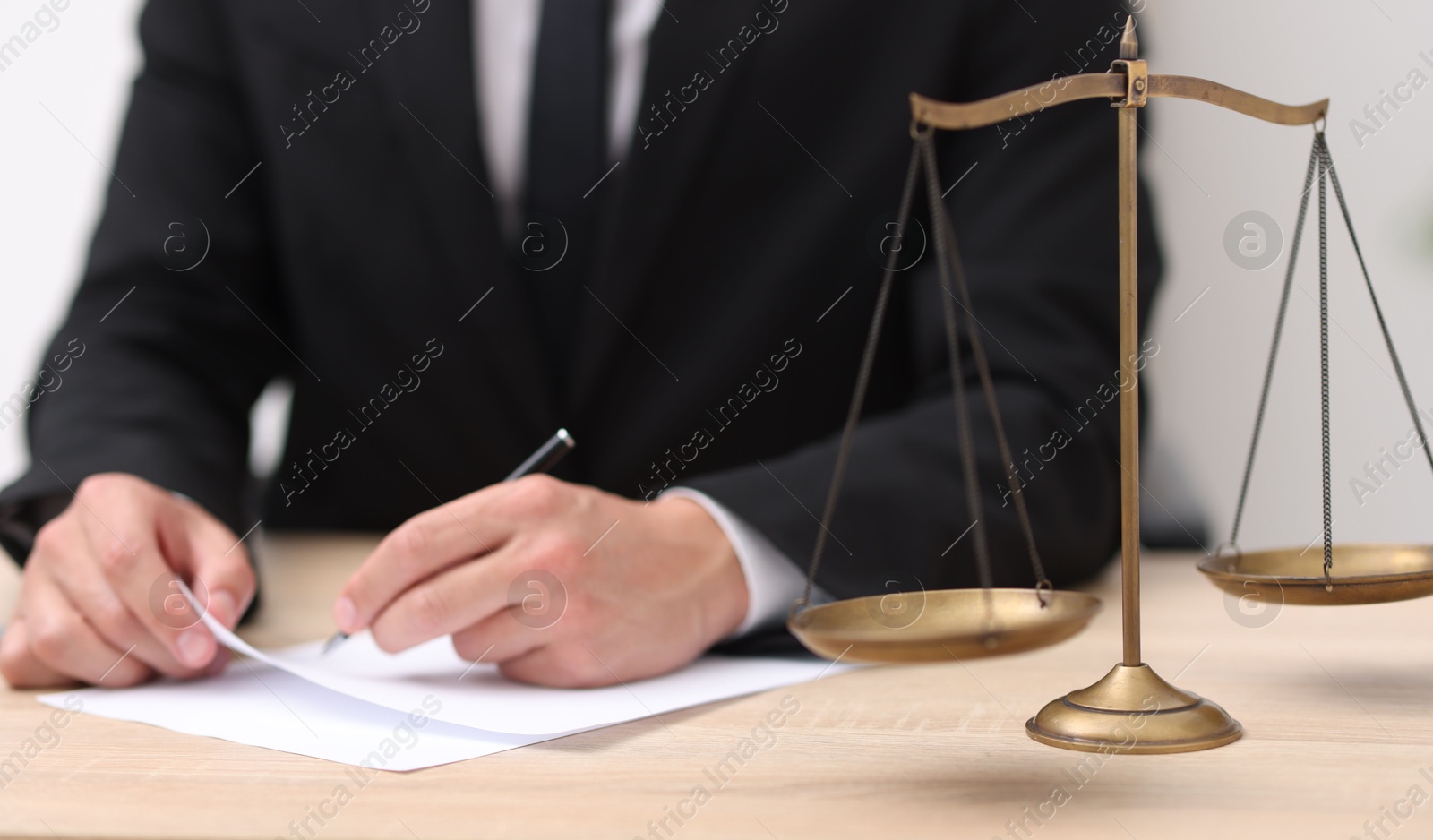 Photo of Judge working and scales on desk indoors, selective focus