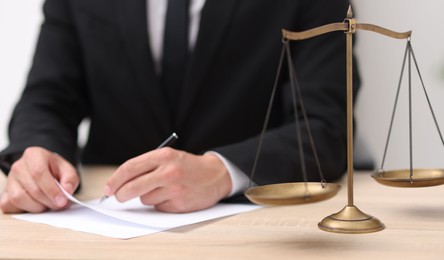Photo of Judge working and scales on desk indoors, selective focus