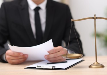 Photo of Judge working and scales on desk indoors, selective focus