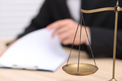 Photo of Judge working and scales on desk indoors, selective focus