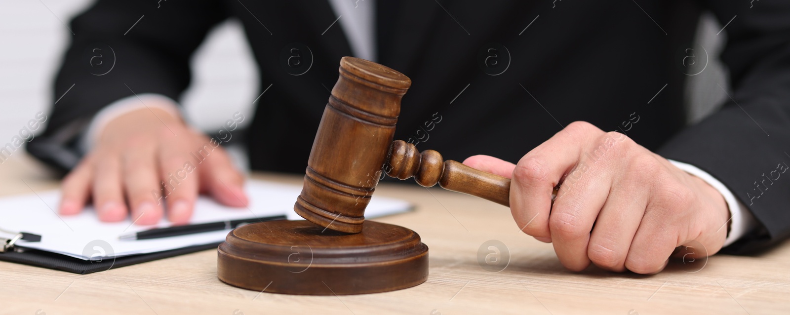 Judge with gavel working at desk indoors, closeup Photo of Judge with gavel working at desk indoors, closeup