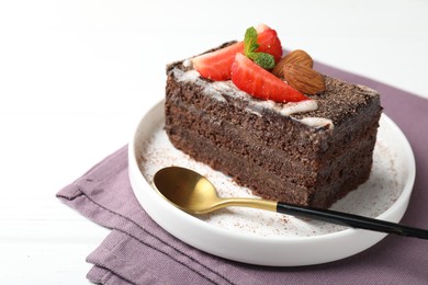 Photo of Piece of delicious chocolate cake with strawberry and almonds on white table, closeup. Space for text