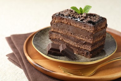 Photo of Piece of delicious chocolate cake with mint on table, closeup