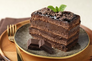 Photo of Piece of delicious chocolate cake with mint on table, closeup