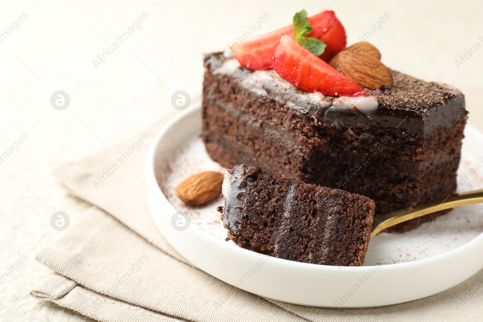 Piece of delicious chocolate cake with strawberry and almonds on table, closeup. Space for text Photo of Piece of delicious chocolate cake with strawberry and almonds on table, closeup. Space for text